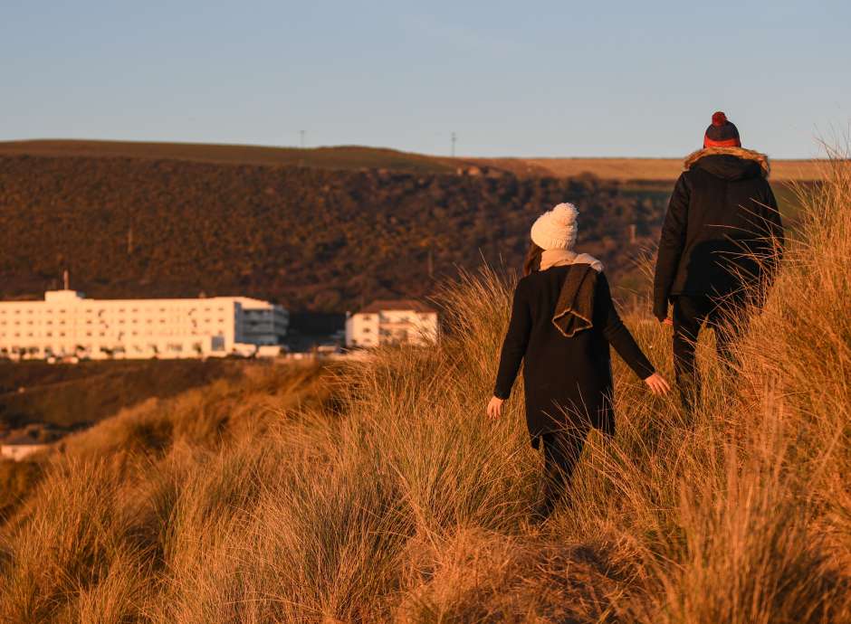Couple walking down the dunes during winter