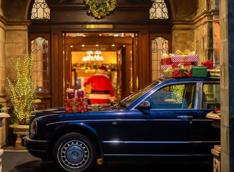 Rolls Royce Parked at Entrance and Santa Walking into the Victoria Hotel with Gifts