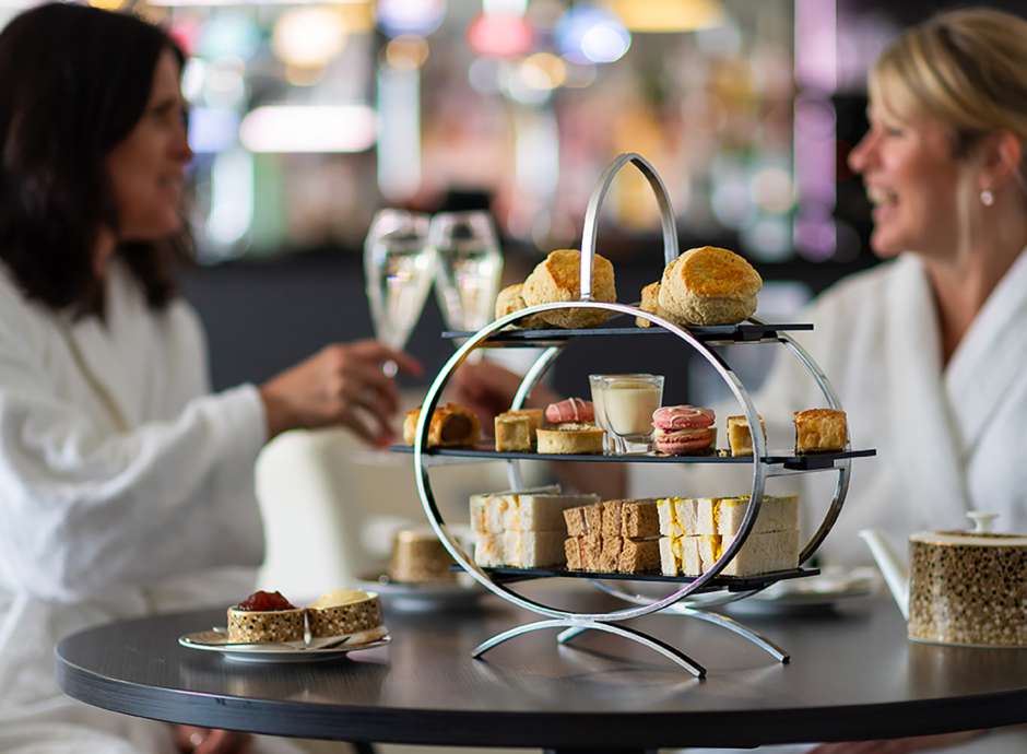 Women enjoying an Afternoon Tea with a pot of tea and glass of prosecco 