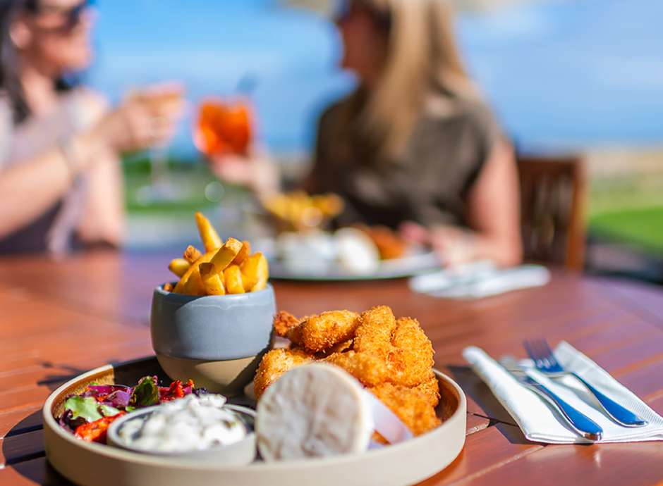 Two woman dining alfresco with drinks on the terrace