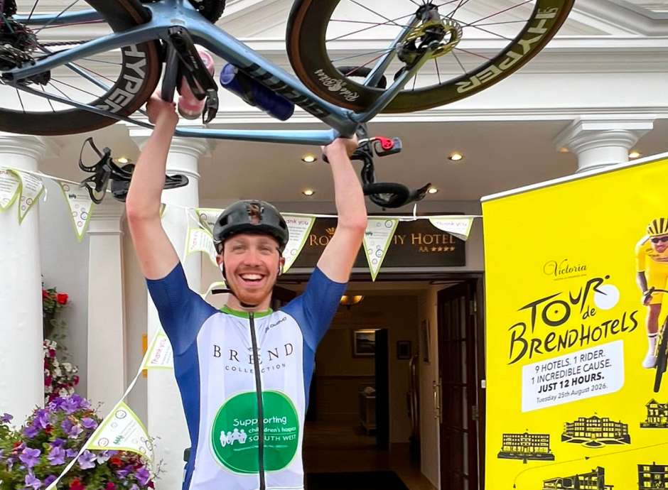 Aidan lifting his bike in the air outside the Royal Duchy Hotel