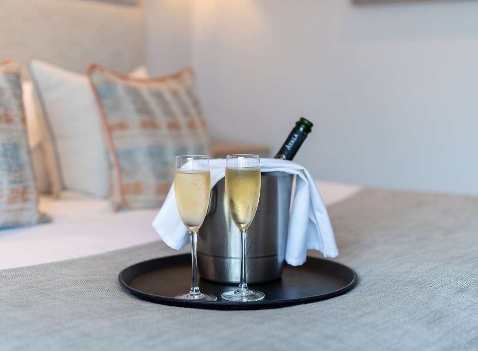 Bottle and two glasses of Champagne on the bed at The Royal Duchy Hotel