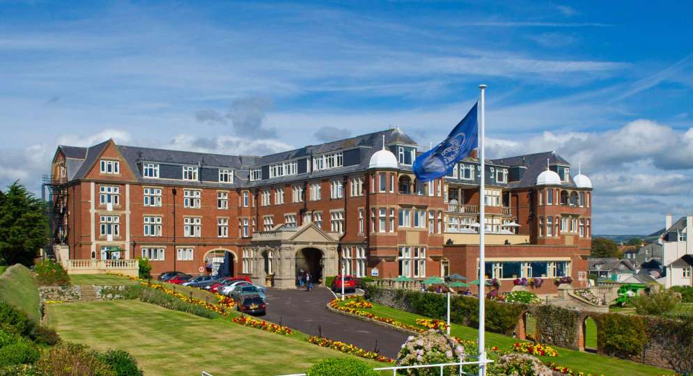 Victoria Hotel External View with Flag and Gardens